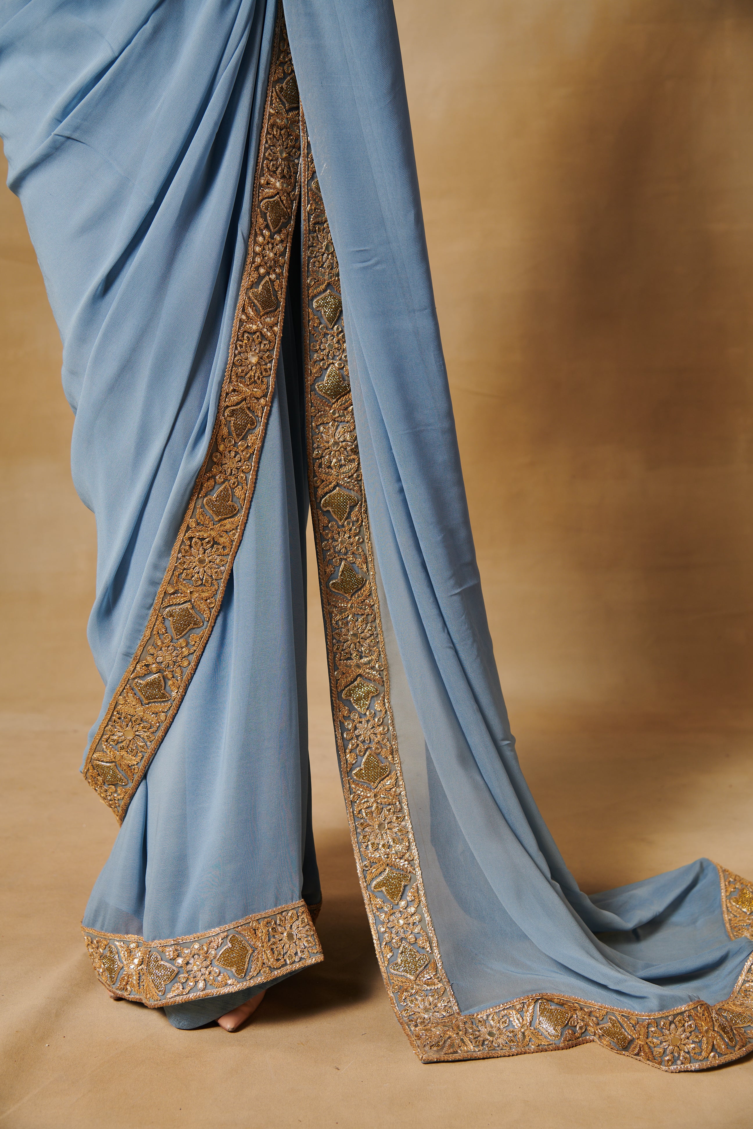 Powder blue georgette saree with all over gold blouse